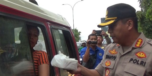 Kapolresta Palembang Kombes Pol Wahyu Bintono Hari Bawono, membagi takjil kepada salah satu penumpang kendaraan umum.