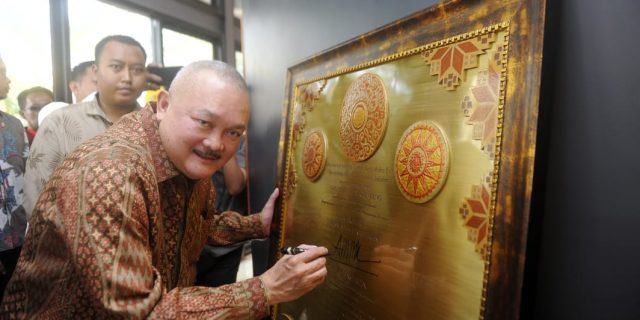 Gubernur membubuhkan tandatangan disebuah lukisan.